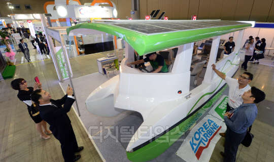 글로벌 태양광 산업 동향을 제시하고 관련 산업의 활성화 및 수출 증대를 위한 '2015 세계태양에너지 엑스포'가 9일 고양시 킨텍스에서 개막됐다.전시장을 찾은 관람객들이 별도의 동력 없이 태양광으로 운항하는 보트를 살펴 보고 있다.  김민수기자ultrartist@